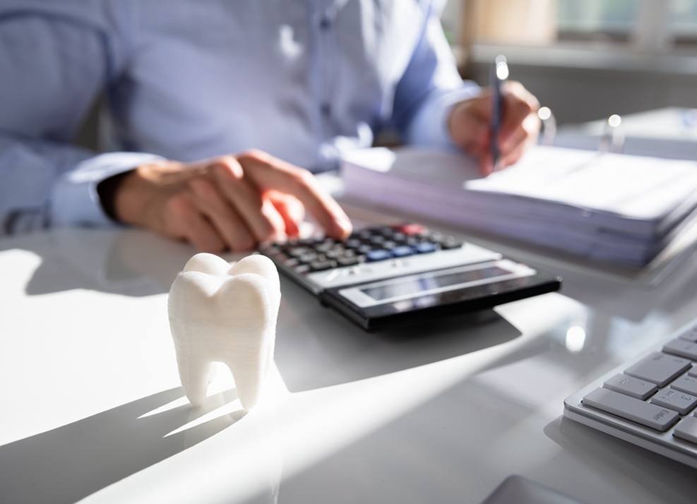 Man using calculator to budget for dental care