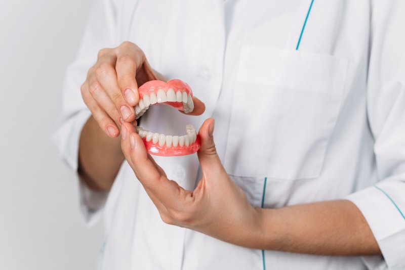 dentist holding dentures