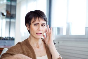 Woman touching her ear looking concerned