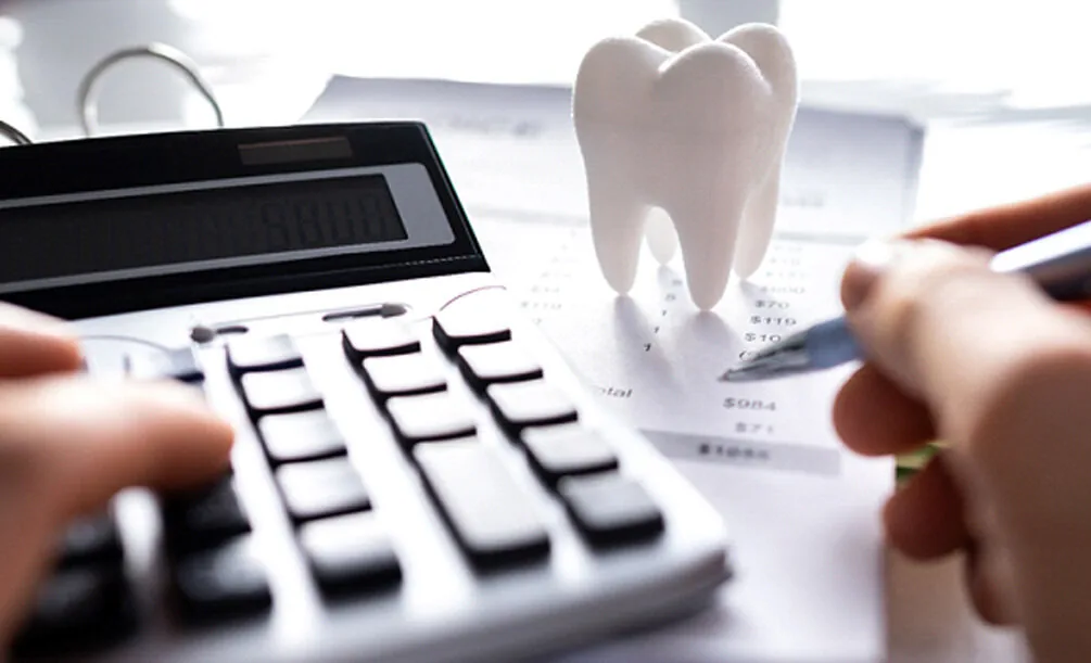 Person using a pen to plan dental care costs