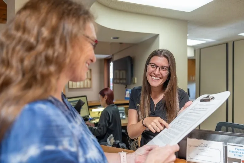 Dental team member talking to a patient about insurance