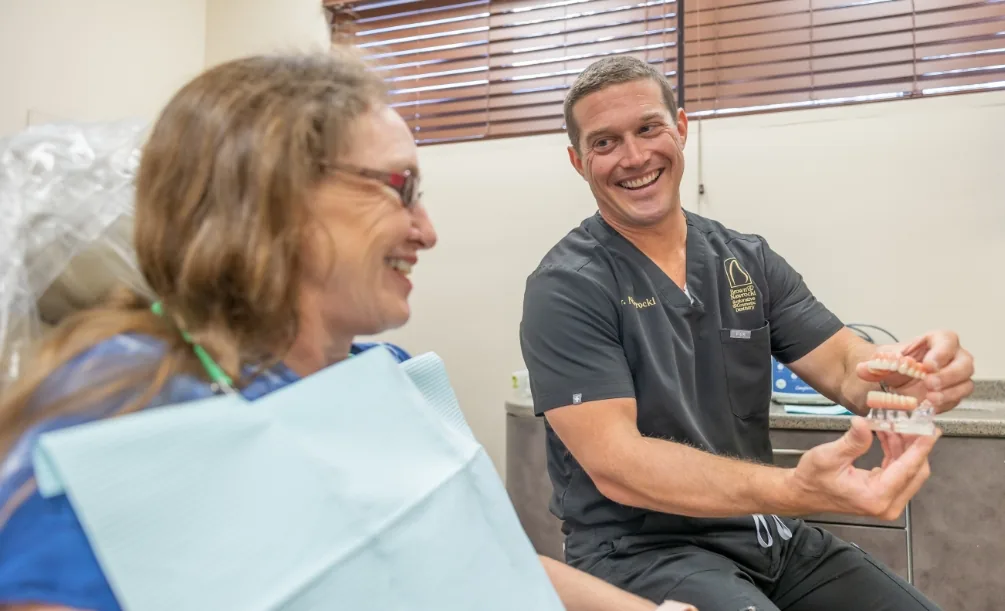 Doctor showing a tooth model to a dental patient