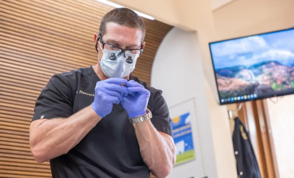 Doctor Nawrocki wearing dental binoculars while examining an item
