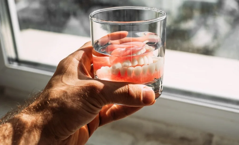 Dentures soaking in a glass of water