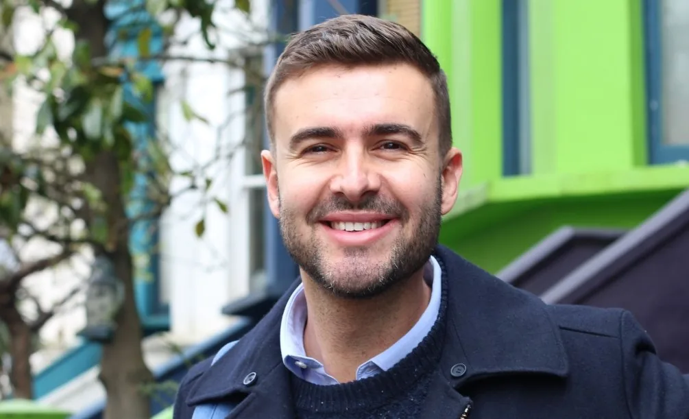 Man standing outdoors with a confident smile