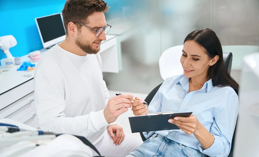 Dental team member reviewing paperwork with a patient