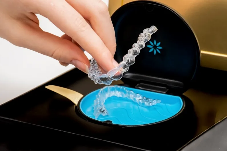 Person placing an Invisalign aligner in its storage case
