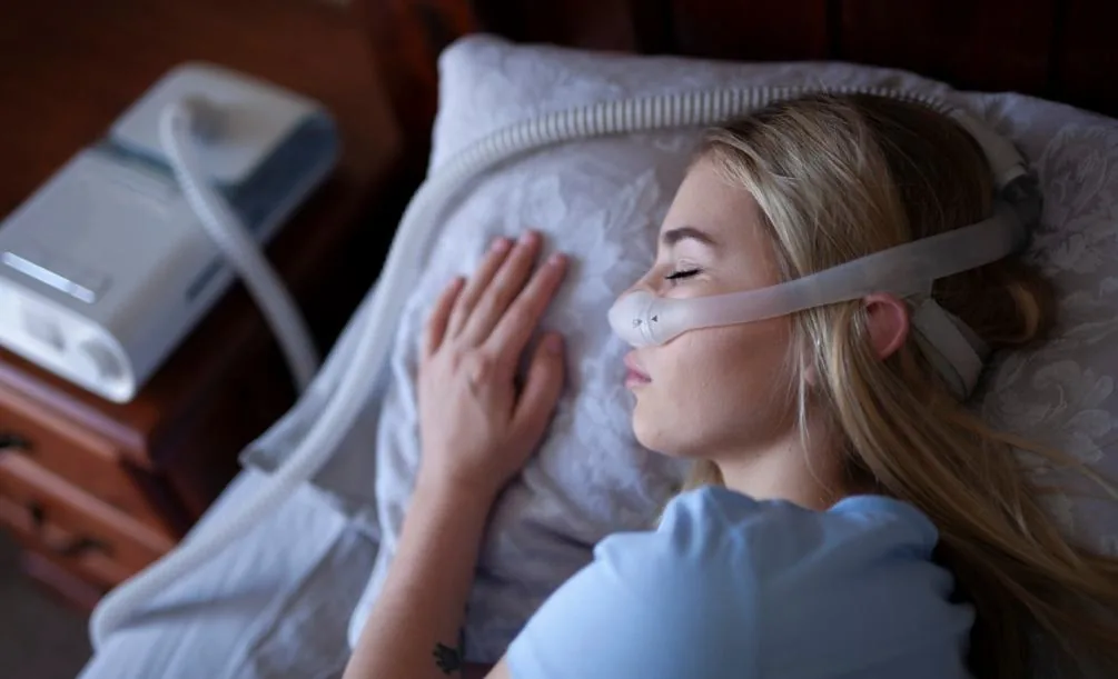 Woman sleeping while wearing CPAP
