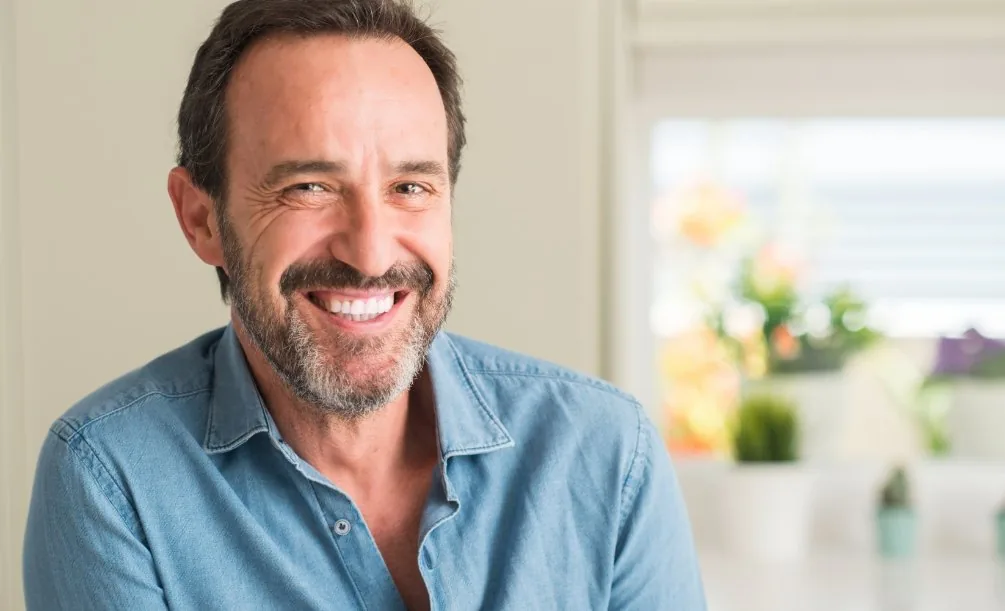 Man smiling in a denim shirt