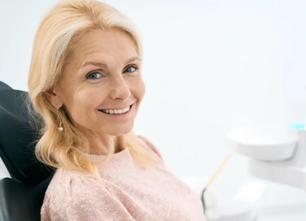 Woman smiling while sitting in a dental chair