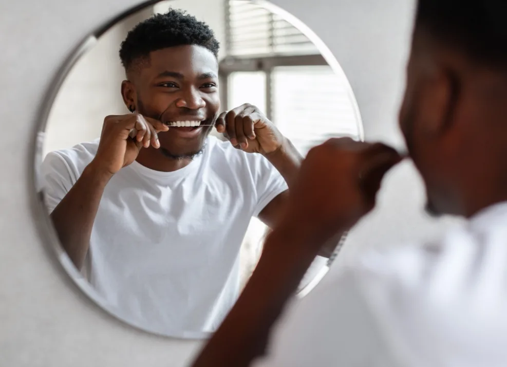 Young man flossing his teeth