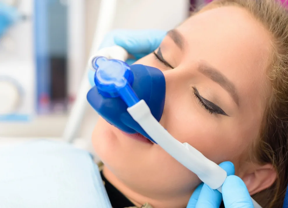 Young woman wearing a nitrous oxide mask during dental treatment